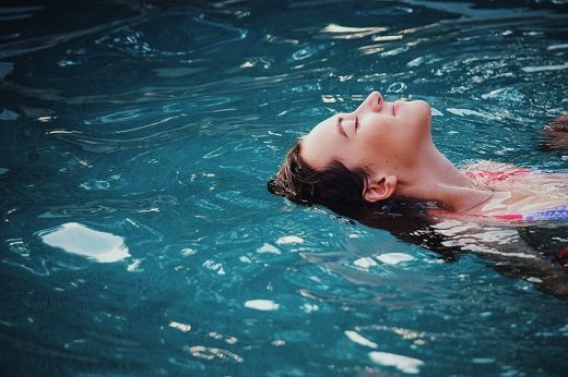 Kobieta unosi się na czystej wodzie w basenie